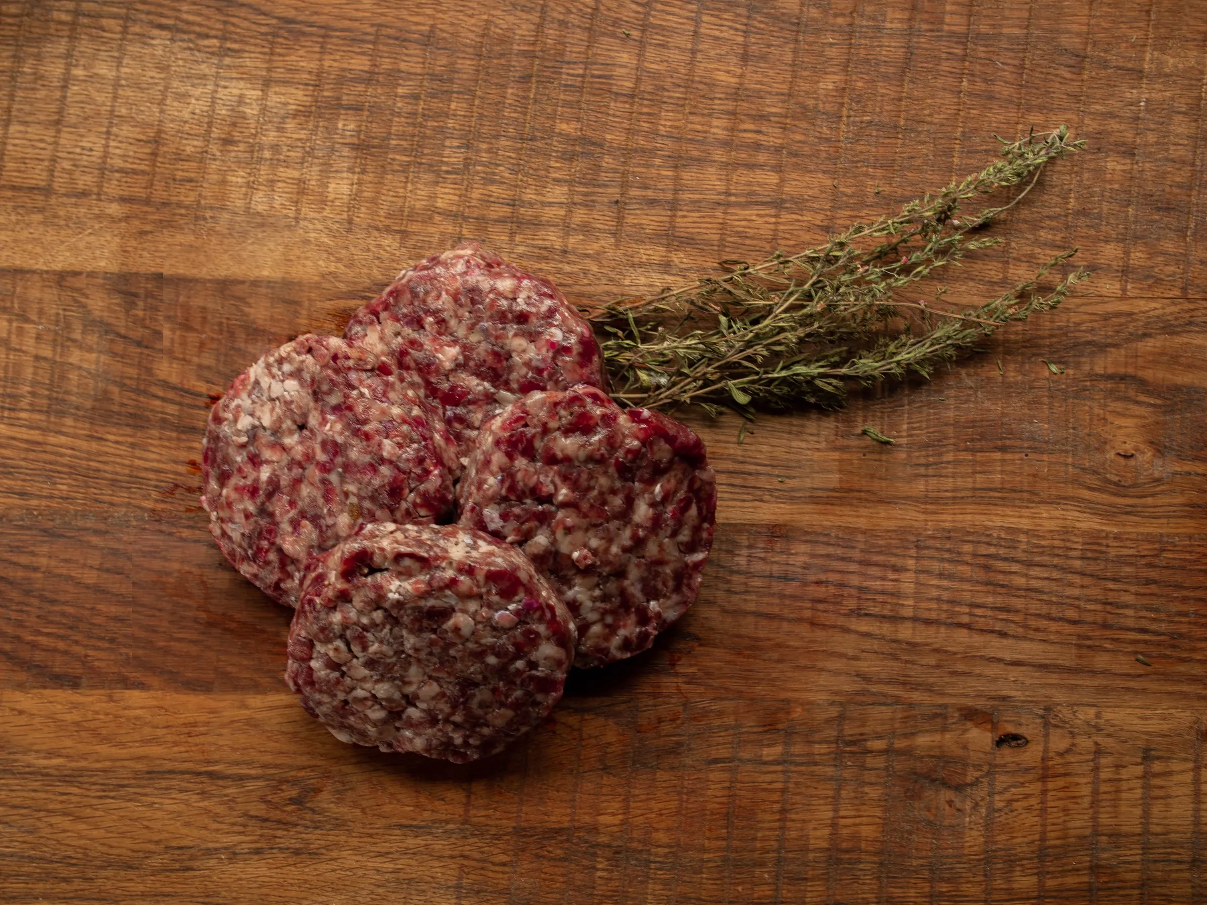 Hamburgers van Angus Grand Cru, rauw op een plank