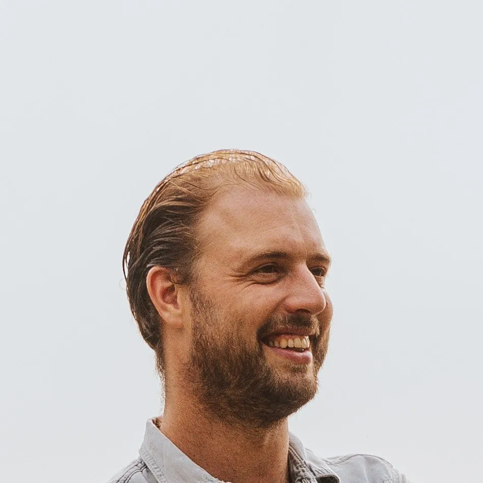 Ludovic Ghyselen glimlacht, met de armen gekruist, in de weide