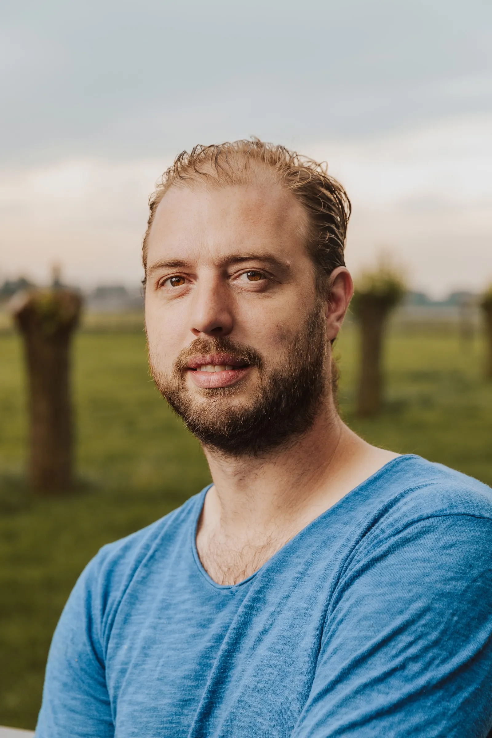 Portret van Ludovic Ghyselen in een blauw T-shirt, in de weide