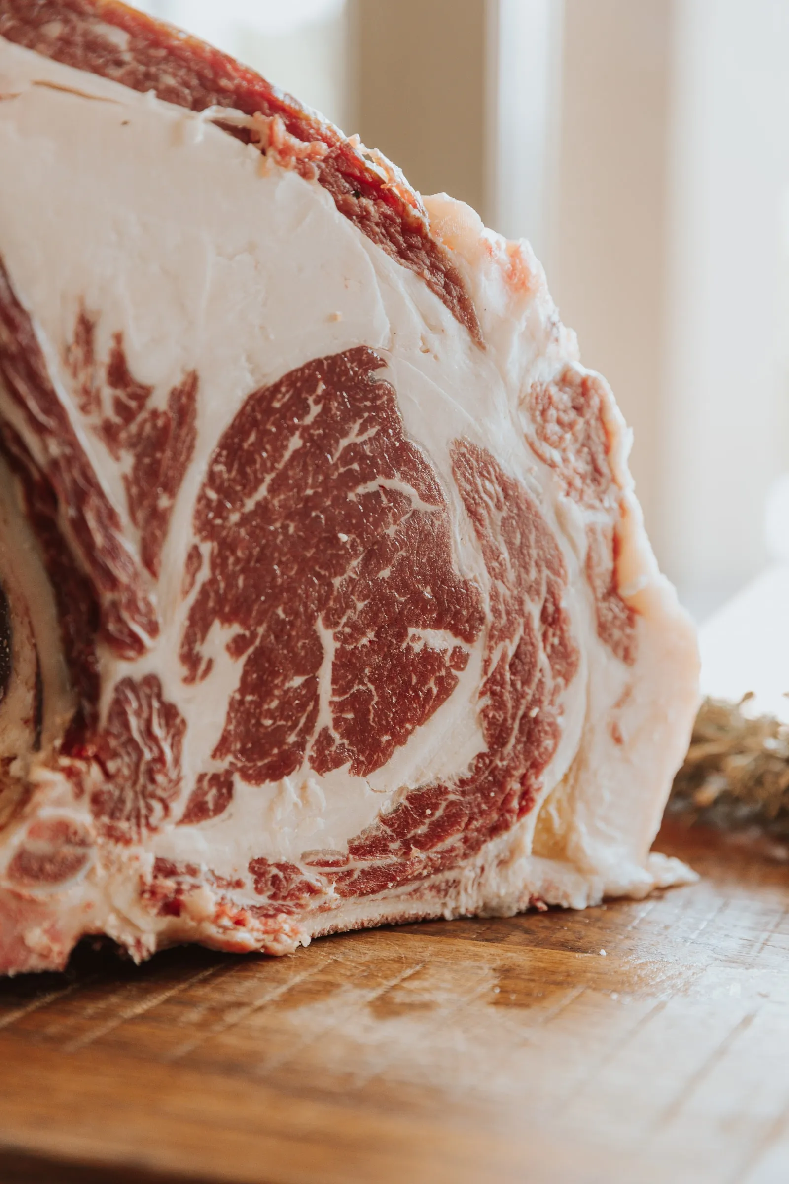 Een rauw ribstuk met been, de marmering duidelijk zichtbaar in het vlees